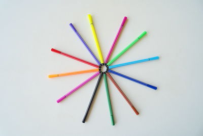 High angle view of multi colored pencils against white background