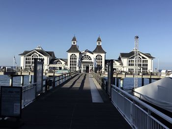 Buildings on pier against clear blue sky