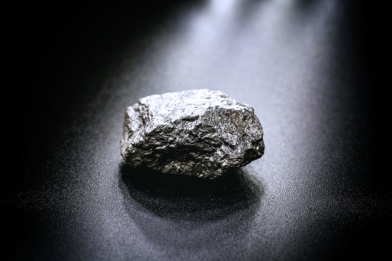 HIGH ANGLE VIEW OF STONE ON ROCK IN BLACK BACKGROUND