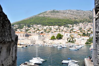 Aerial view of townscape by sea against sky