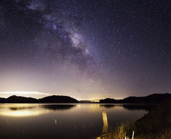 Scenic view of lake against sky at night