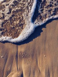 Close-up of tire tracks on beach