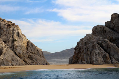 Rock formations by sea against sky