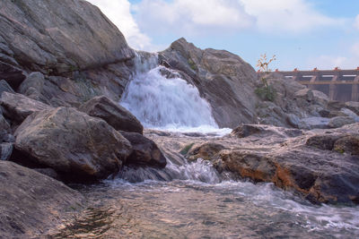 Scenic view of waterfall against rocks