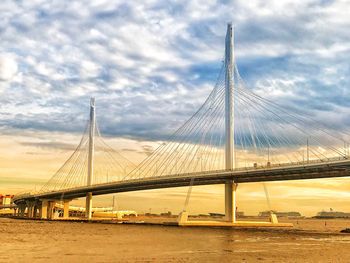 View of suspension bridge against cloudy sky