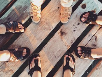 Low section of people standing on hardwood floor