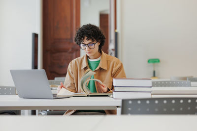 Businesswoman using laptop at desk in office