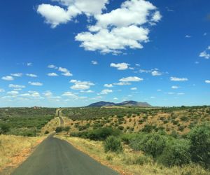 Road along countryside landscape against blue sky