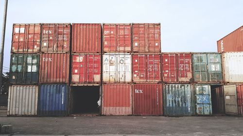 Stack of red metallic structure against sky