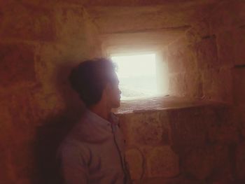 Close-up of young woman standing against wall