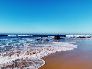 Scenic view of sea against clear blue sky