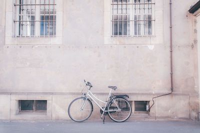 Bicycle parked against wall of building