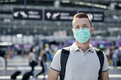 Man wearing face during travel by airplane. passenger walking to check-in counter at airport.