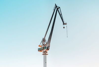 Low angle view of crane against clear sky