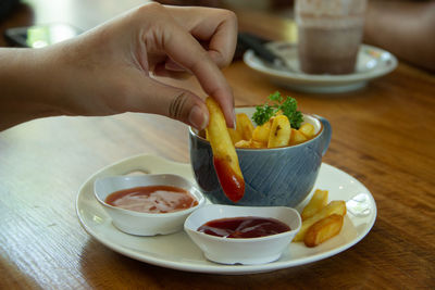 Midsection of person having food on table