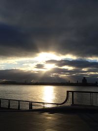 Pier on sea against cloudy sky