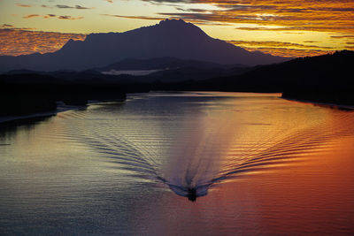 Boat sailing on river during sunset