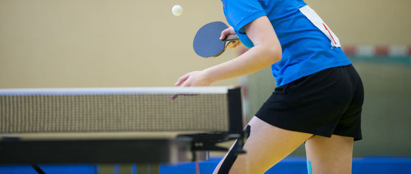 Midsection of player holding table tennis racket