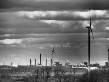 Wind turbines on field against sky