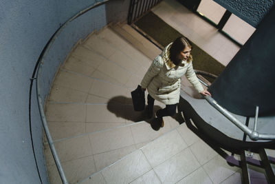 High angle view of woman sitting on tiled floor