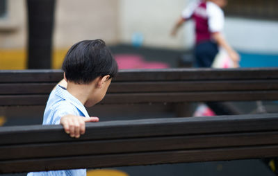 Rear view of boy looking at railing