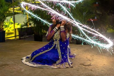 Low angle view of illuminated lighting equipment at night