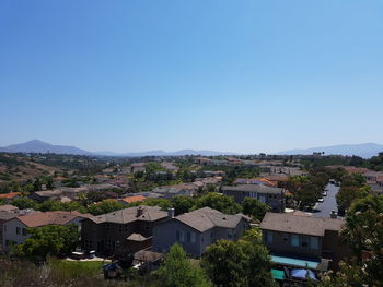 High angle view of houses against clear blue sky