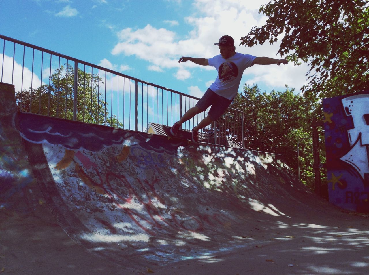 full length, sky, jumping, lifestyles, leisure activity, casual clothing, low angle view, childhood, mid-air, fun, person, tree, standing, built structure, day, enjoyment, balance, young adult