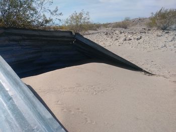Sand dune on beach against sky