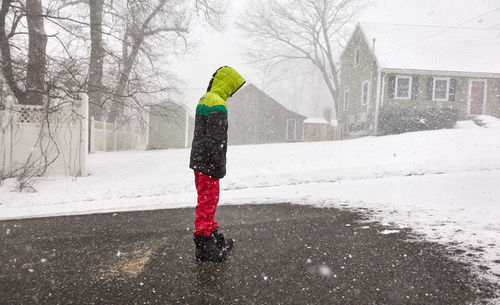 Man standing on snow covered tree