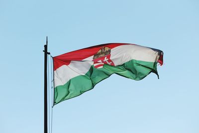 Low angle view of flag against clear blue sky