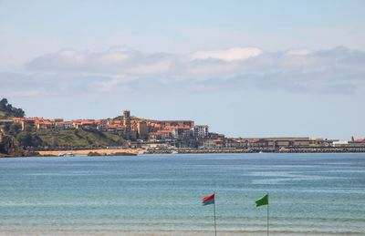 Scenic view of sea and buildings against sky