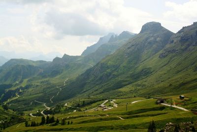 Scenic view of green landscape and mountains against sky