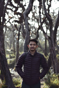 Portrait of young man standing in forest