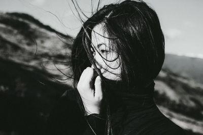 Beautiful young woman looking away while standing outdoors