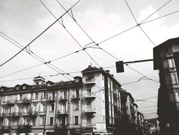 Low angle view of buildings against cloudy sky