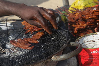 Close-up of person preparing food on barbecue grill