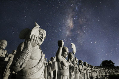 Low angle view of angel statue against sky at night