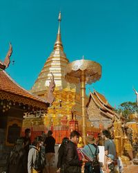 Group of people in traditional building against clear sky