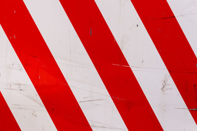 Red and white diagonal stripes on flat steel sheet - caution road sign