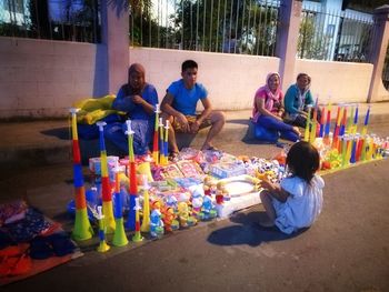 Friends sitting on multi colored umbrellas