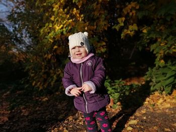 Cute baby girl standing in park during autumn