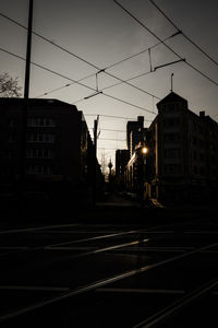 Road by buildings in city at dusk