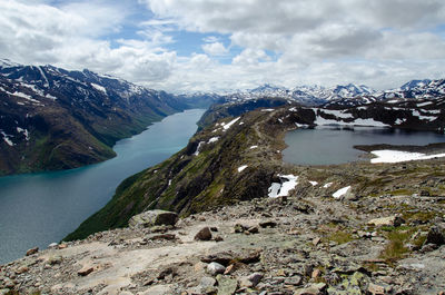Scenic view of lake by snowcapped mountains against sky