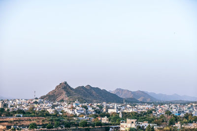 High angle view of houses in town against clear sky