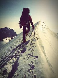 Rear view of people walking on snow covered land