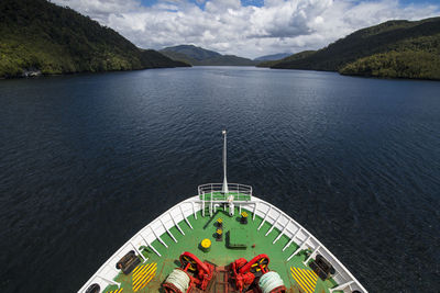 Passenger vessel navigating through narrow fjord in patagonia