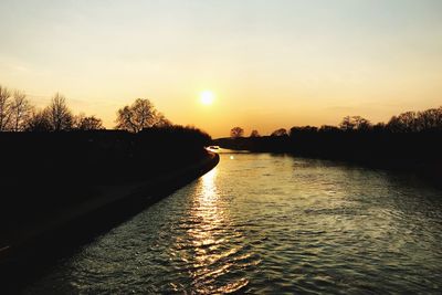 Scenic view of river against sky during sunset