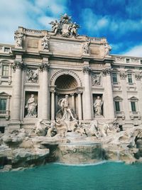 Trevi fountain against cloudy sky