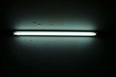 Low angle view of illuminated lights on wall in darkroom